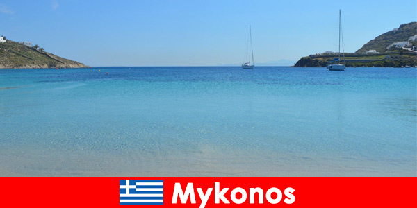 Wczasowicze kochają słońce i krystalicznie czystą wodę w Mykonos w Grecji